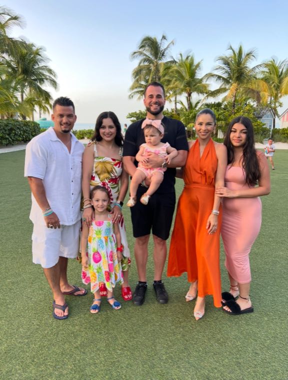 An EIB family together on the lawn of an island resort during a team trip